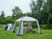 Couple dining under a gazebo event shelter with festoon lights pitched in a grass field next to a camping tent