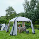 Couple dining under a gazebo event shelter with festoon lights pitched in a grass field next to a camping tent