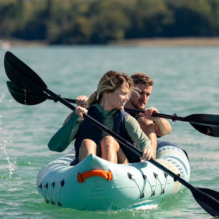 Two people kayaking on the water in Coleman lifejackets