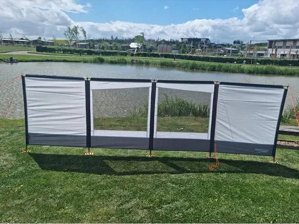 Carnival windbreak pitched standalone in a grassy field as an outdoor lifestyle shot