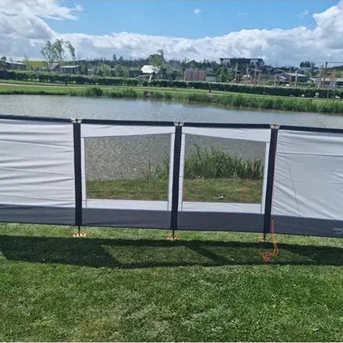 Carnival windbreak pitched standalone in a grassy field as an outdoor lifestyle shot