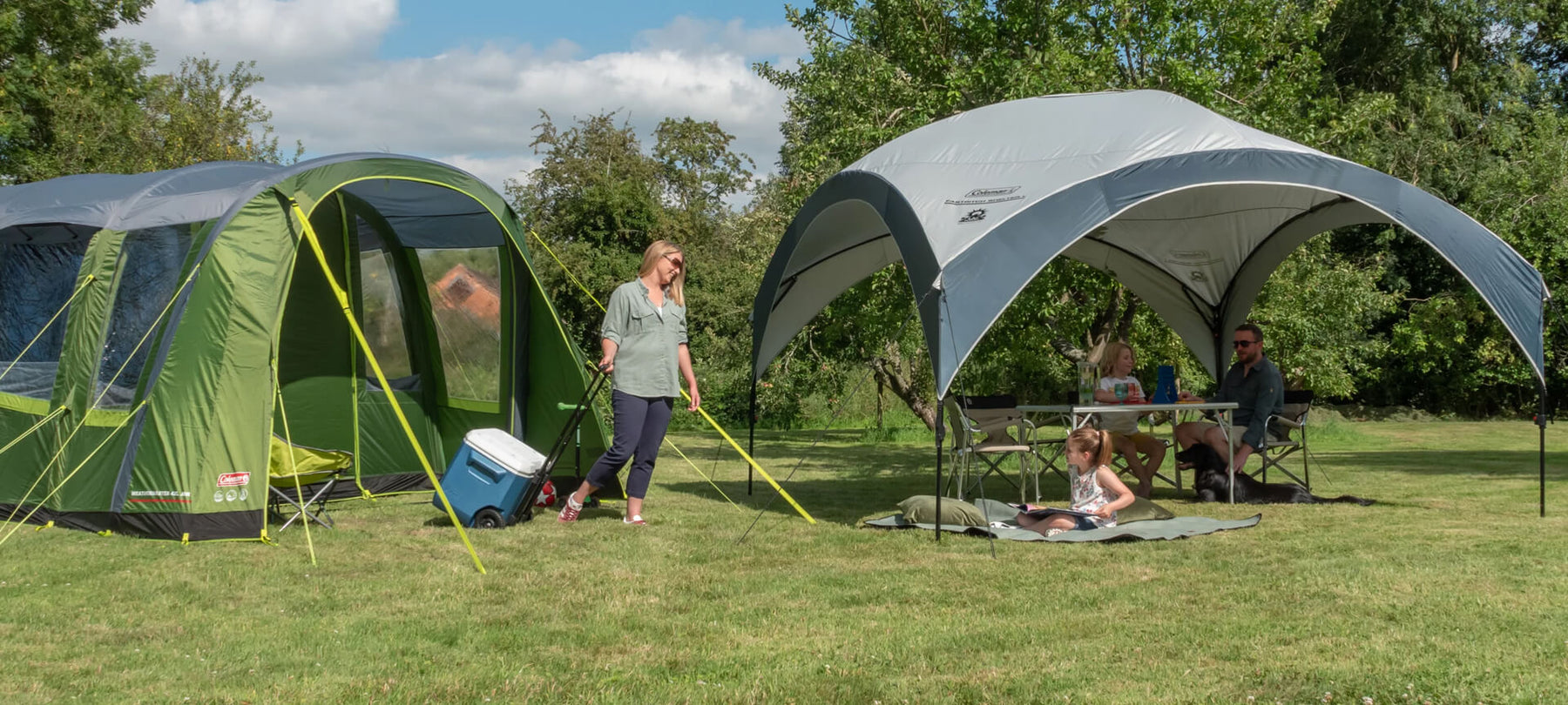 Coleman tent and canopy combination with people smiling in a complete sunshine camping setup