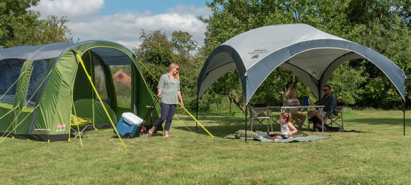 Coleman tent and canopy combination with people smiling in a complete sunshine camping setup