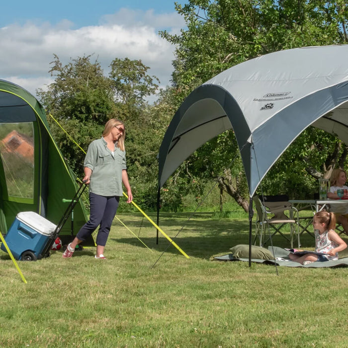 Coleman tent and canopy combination with people smiling in a complete sunshine camping setup