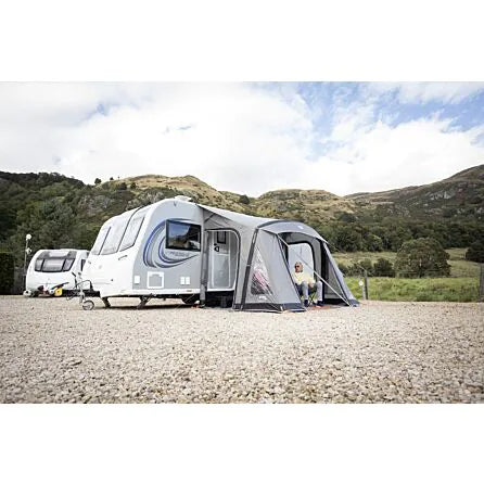 Vango Palma Air 330 inflatable porch awning attached to a caravan parked on a campsite in sunshine