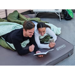 Two adults reading in sleeping bags on a Summit air bed inside a tent
