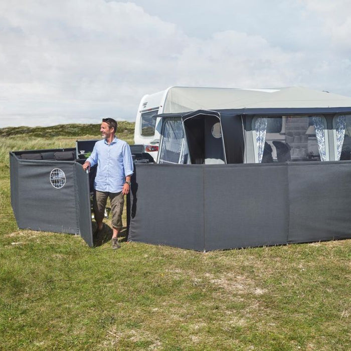 Isabella windscreen pitched at a family caravan setup
